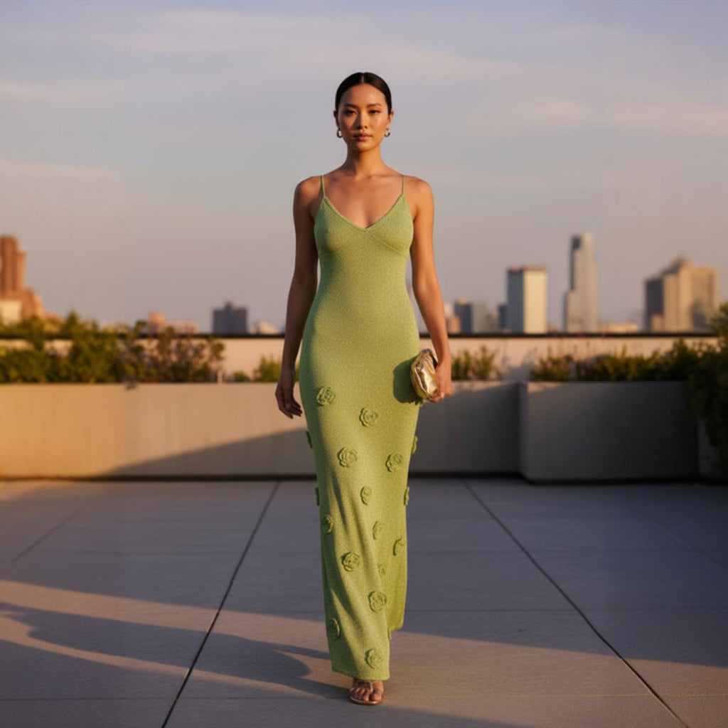 Woman in a green dress standing on a rooftop with city skyline in the background