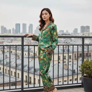 Woman in a green patterned outfit standing on a balcony with cityscape in the background