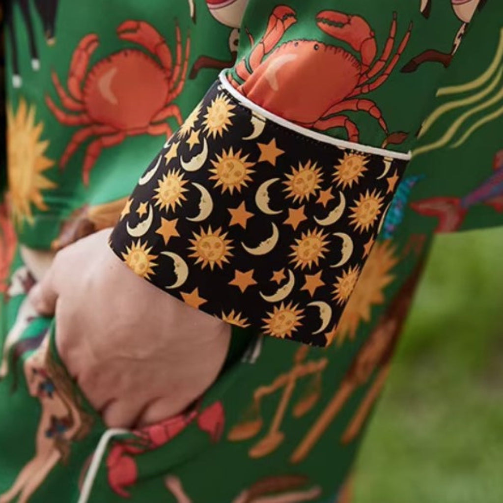 Person wearing a colorful outfit with a pattern of crabs and celestial designs.