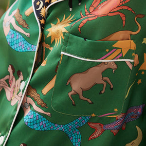 Green fabric with colorful zodiac and mermaid designs, featuring the brand 'DESIGN SENSE'.