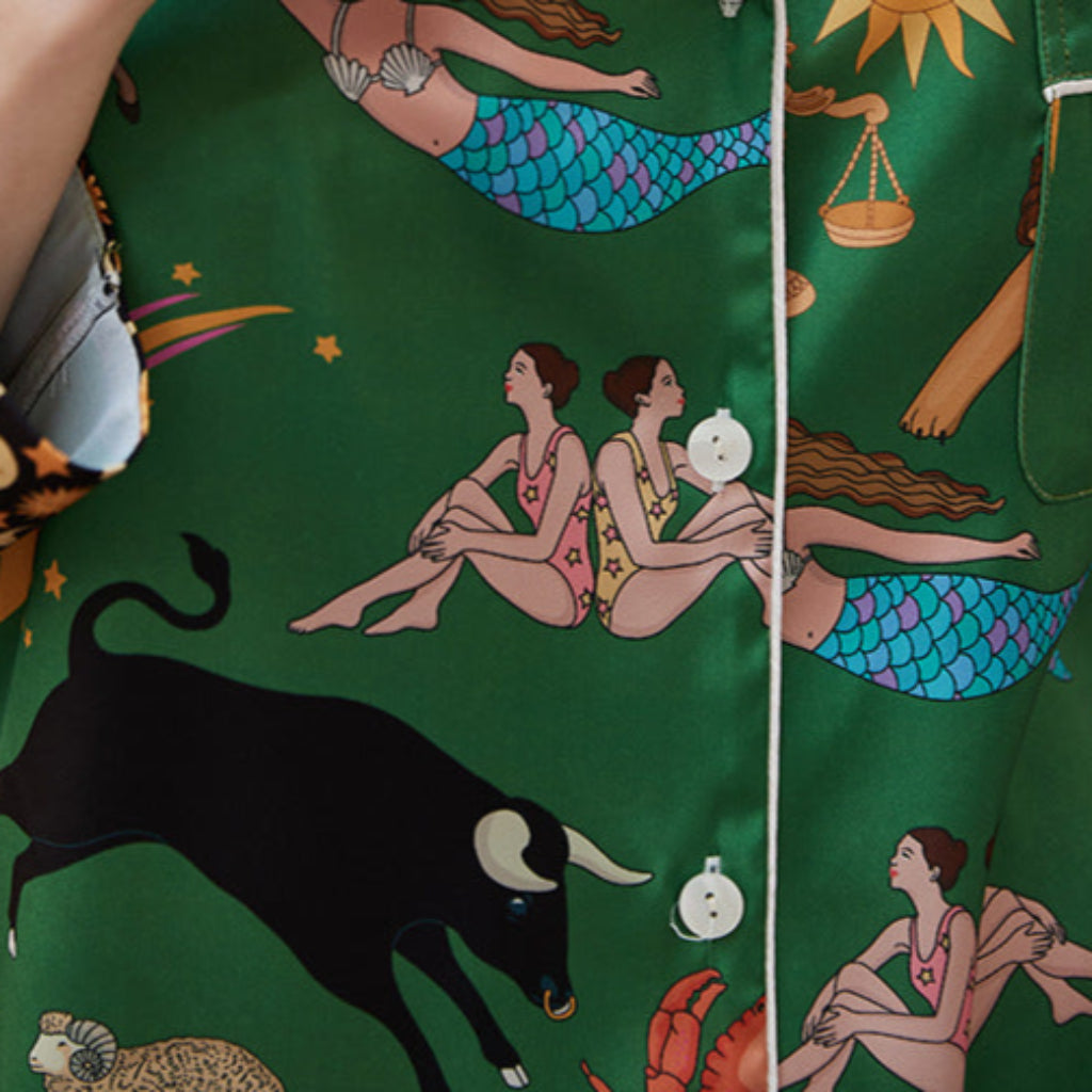 Green fabric with zodiac and mermaid pattern, featuring a black bull illustration.