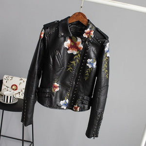Black leather jacket with floral embroidery on a gray background