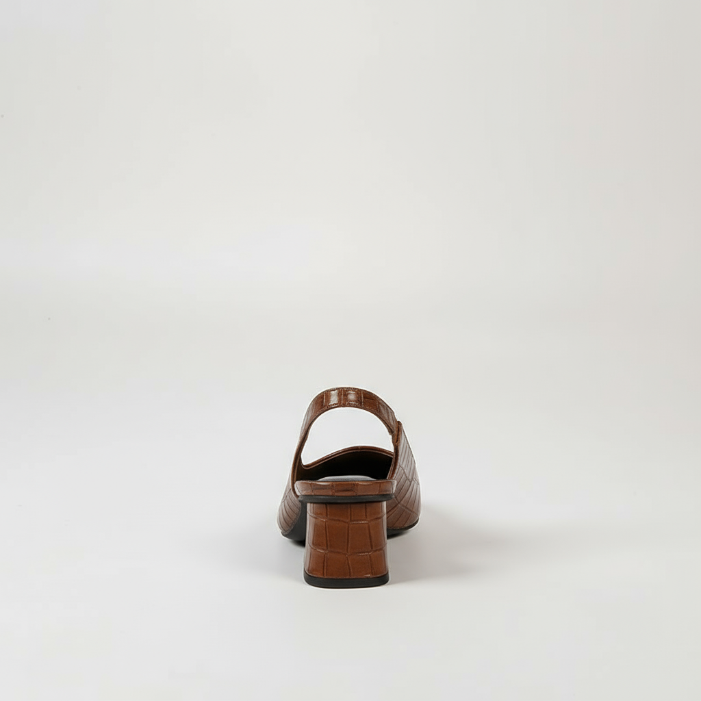Brown crocodile-patterned shoe on a light gray background