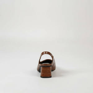 Brown crocodile-patterned shoe on a light gray background