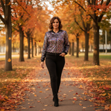 Woman walking on a path lined with trees with autumn foliage