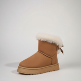 Tan winter boot with white fur trim on a light gray background