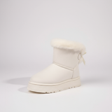 White winter boot with fur trim on a light gray background