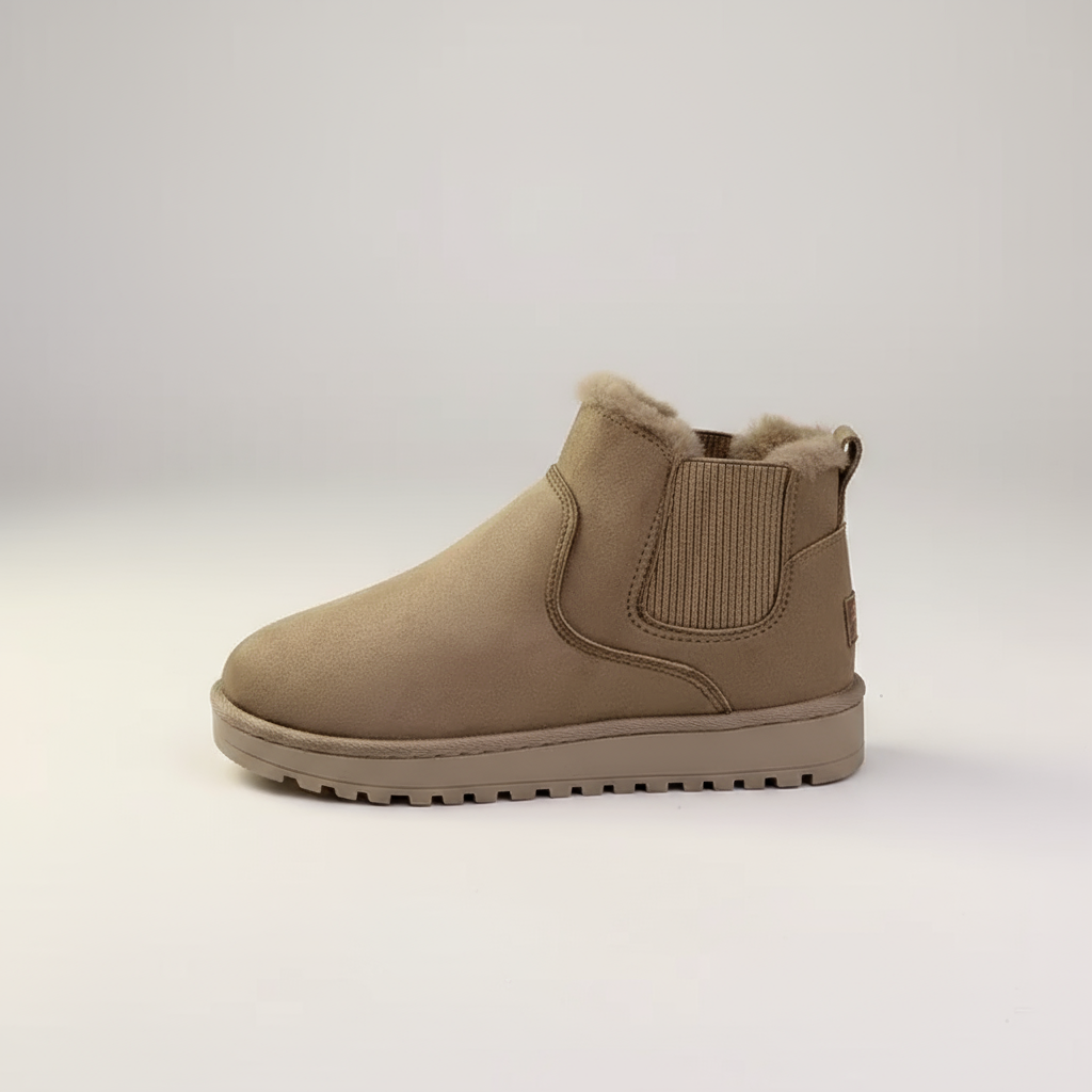 Tan Chelsea boot with fur lining on a light gray background