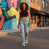 Woman walking on a street with a colorful mural in the background