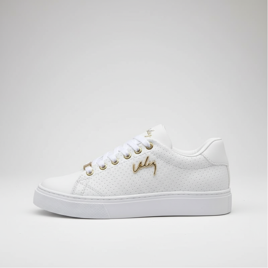 White sneaker with gold accents on a light gray background