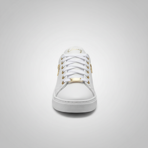 White sneaker with gold accents on a light gray background