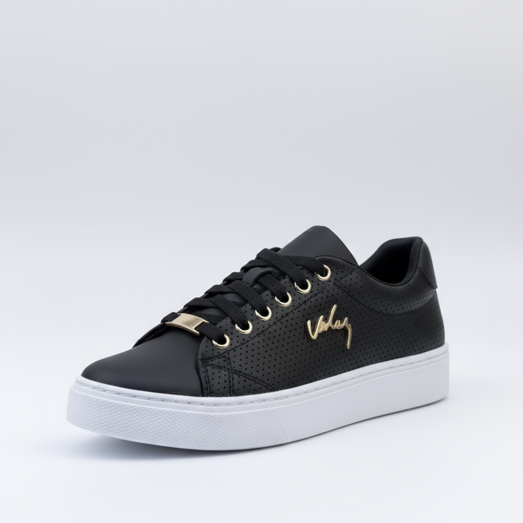 Black sneaker with gold accents on a light gray background