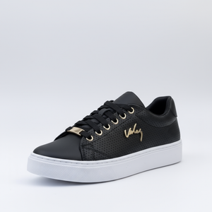 Black sneaker with gold accents on a light gray background