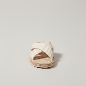 White sandal with woven sole on a light gray background