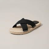 Black sandal with jute sole on a beige background