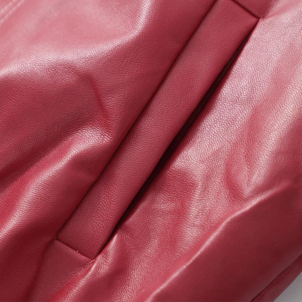 Close-up of a red leather surface with visible texture and folds.