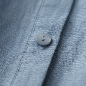 Close-up of a button on a blue fabric shirt