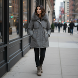 Woman wearing a gray parka with fur hood on a city street