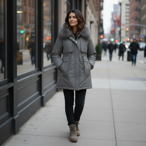 Woman wearing a gray parka with fur hood on a city street