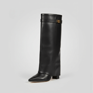 Black knee-high boot with a gold buckle on a light gray background