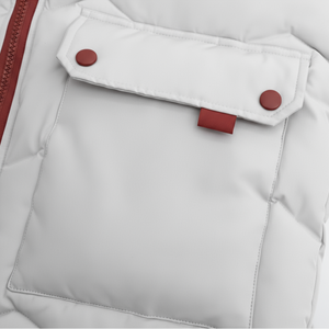 Close-up of a white puffer jacket with red buttons and zipper.