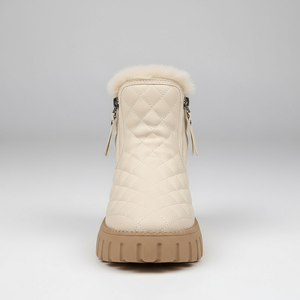 Beige winter boot with quilted design and fur trim on a light gray background