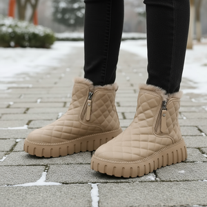 Beige quilted boots with fur trim on a snowy pavement