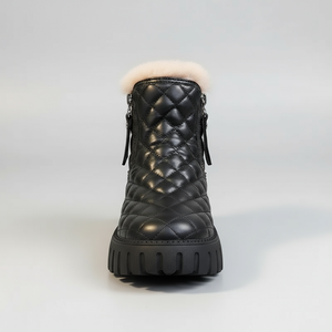Black quilted winter boot with white fur lining on a light gray background