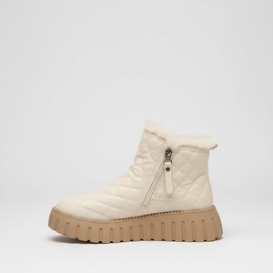 White quilted ankle boot with a brown sole on a light gray background