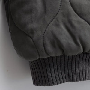 Close-up of a dark gray fabric with ribbed texture on a white background