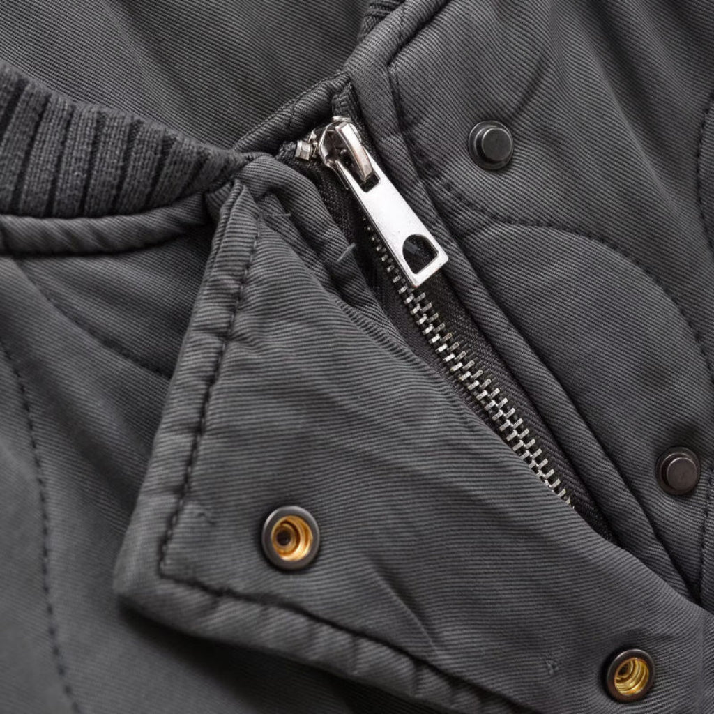 Close-up of a gray jacket with zipper and button details