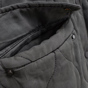 Close-up of a gray jacket with buttons and stitching details