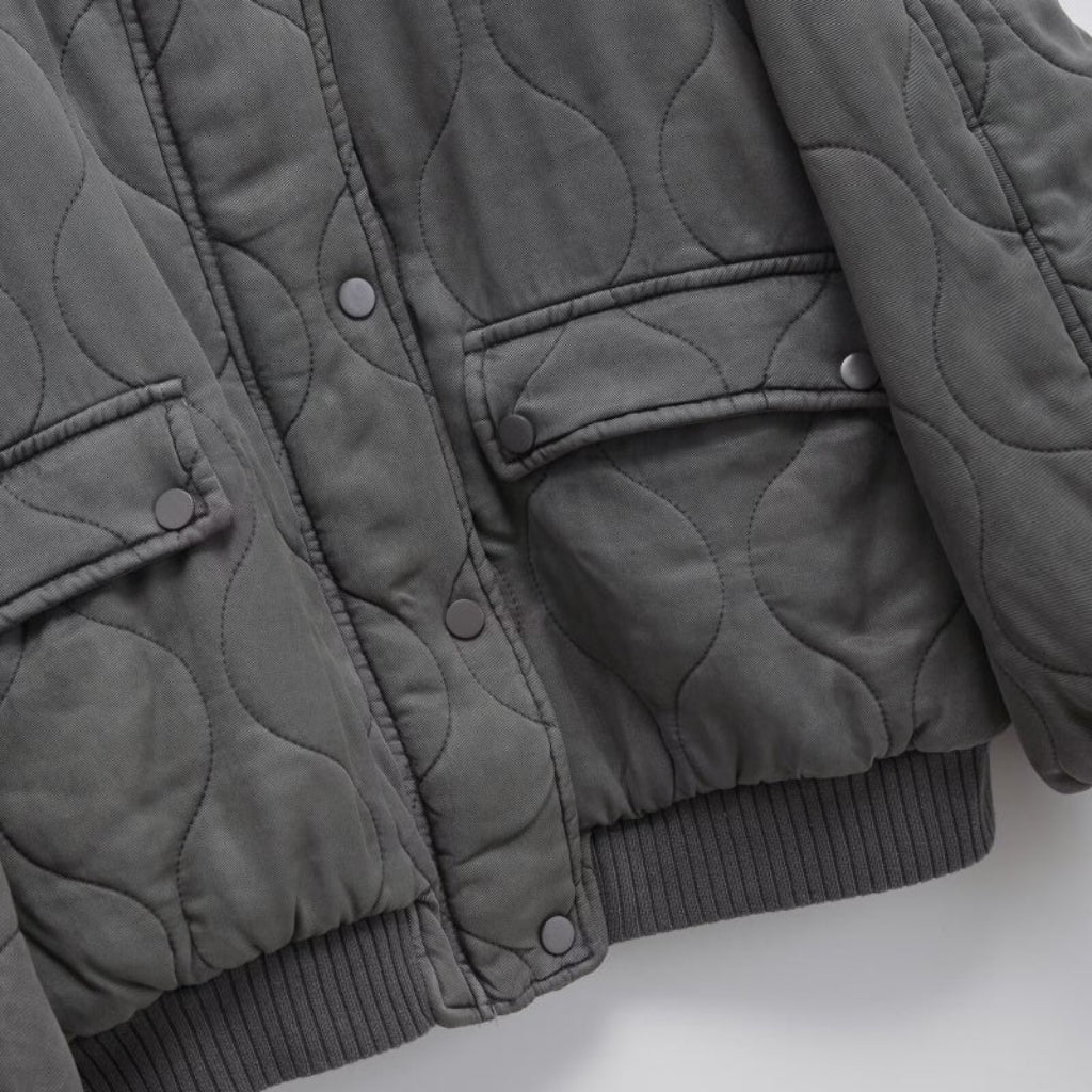 Quilted gray jacket on a light gray background