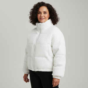 Woman wearing a white ribbed knit sweater against a plain background