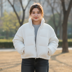 Woman wearing a white puffer jacket in an outdoor setting with trees and grass.