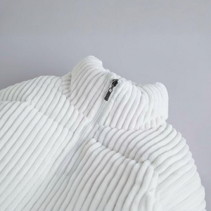 Close-up of a textured white garment with a zipper on a light gray background