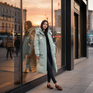 Woman in a light blue puffer coat standing in front of a store window.