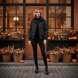 Woman in black outfit standing in front of a store with Halloween decorations