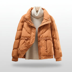 Brown puffer jacket over a white sweater on a light background