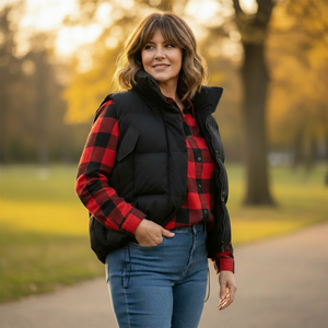 Woman wearing a red and black plaid shirt with a black vest in a park setting
