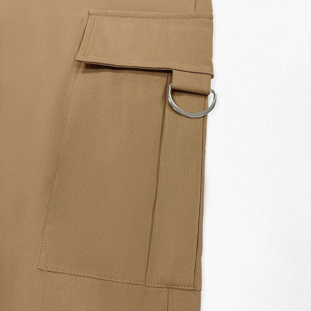 Close-up of beige pants with a belt and buckle on a white background