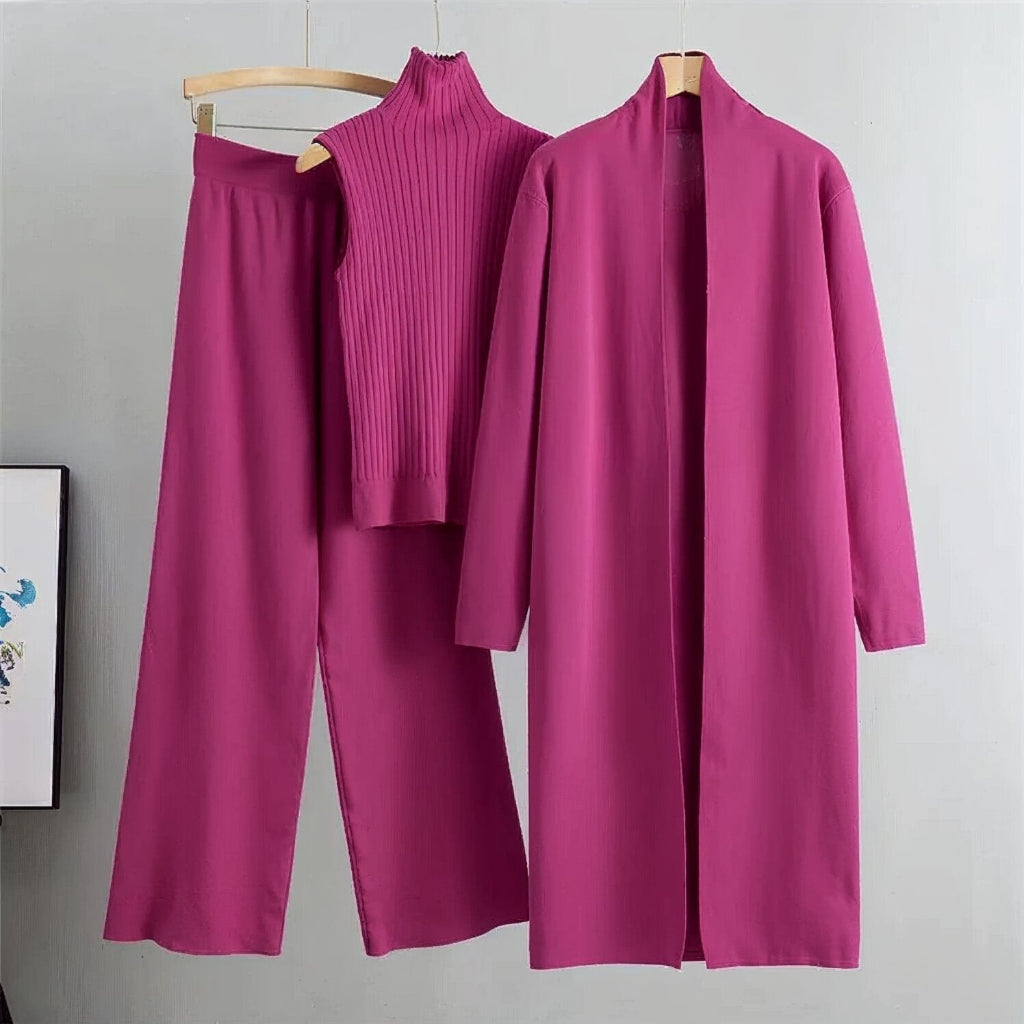 Purple outfit with top, pants, and coat on hangers against a gray background