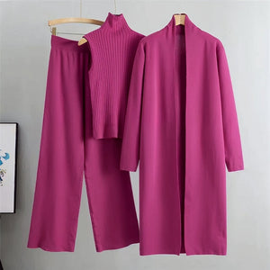 Purple outfit with top, pants, and coat on hangers against a gray background