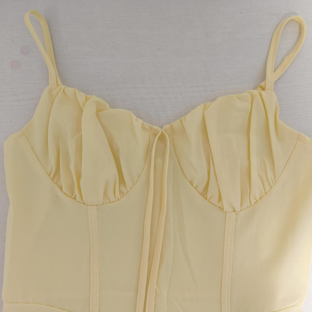 Yellow dress with thin straps on a light gray background