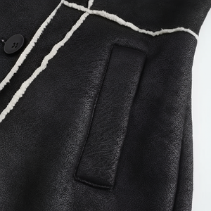 Close-up of a black leather jacket with white trim