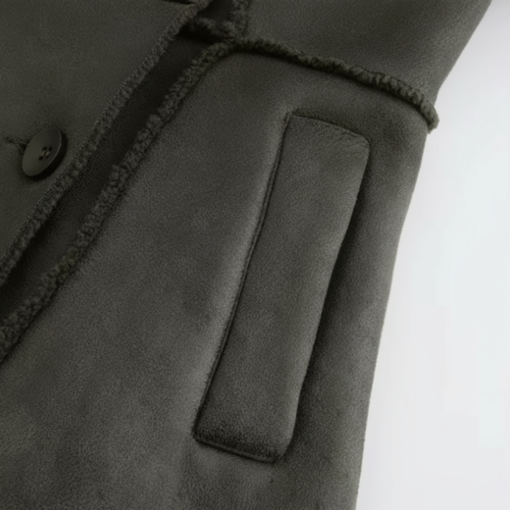 Close-up of a dark gray coat with a button and pocket on a white background