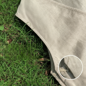 Close-up of a beige fabric with a zipper on grass