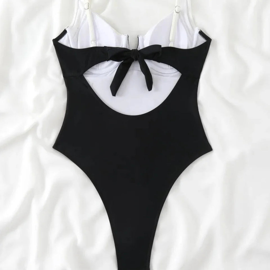 Black one-piece swimsuit with a bow detail on a white background