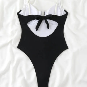 Black one-piece swimsuit with a bow detail on a white background