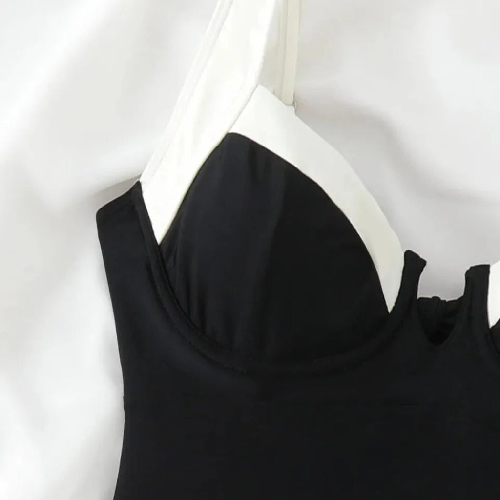Black dress with white trim on a white background